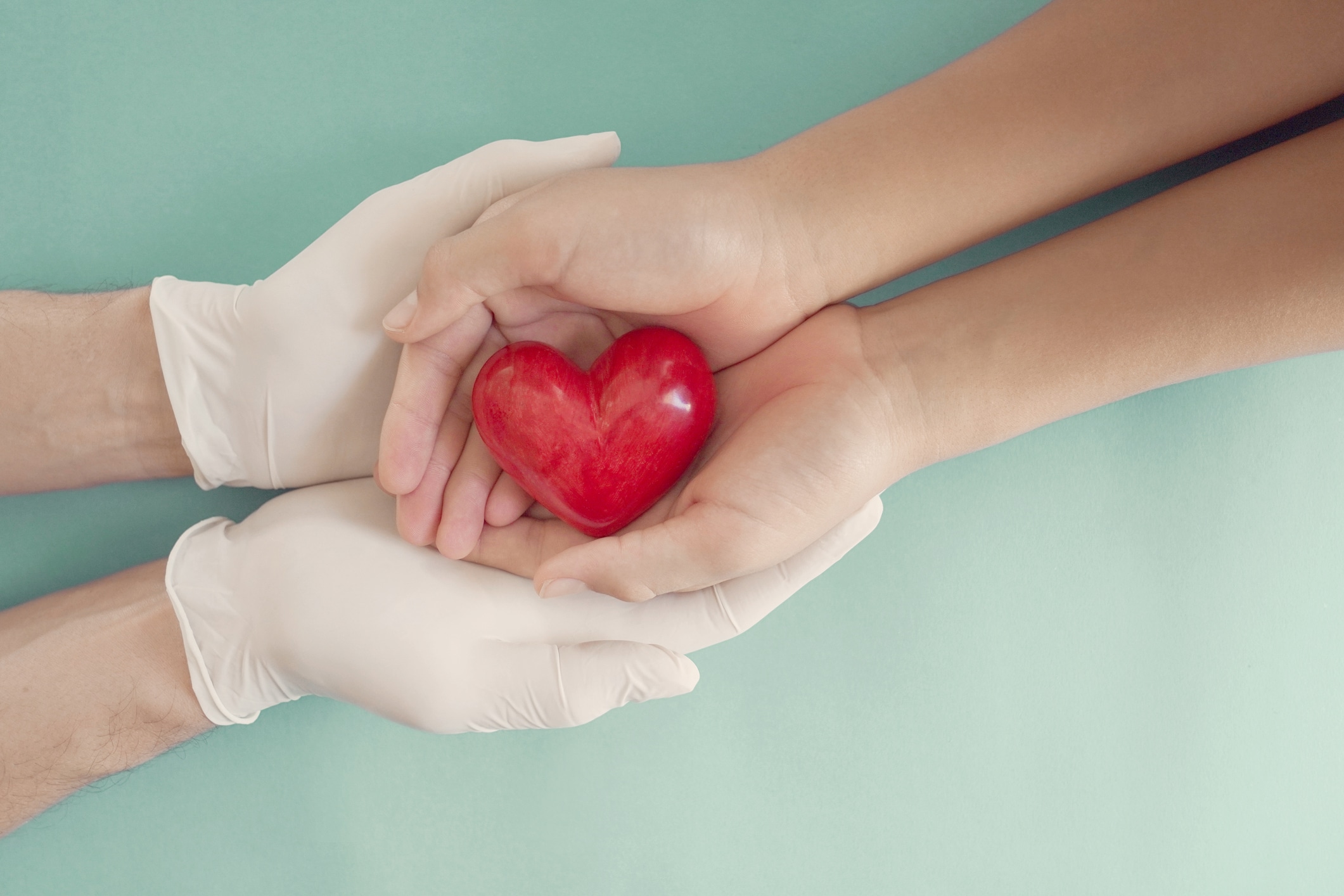 Doctor hands with medical gloves holding child hands and red heart, health insurance, donation, charity during covid-19 coronavirus pandemic, saving life, thank you and appreciation to doctor